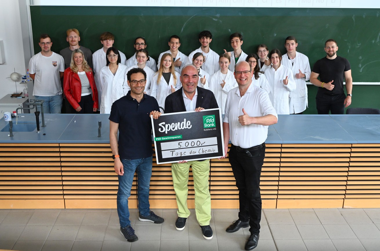 Vorne v.l.n.r.: Prof. Dr. Simone Mascotto, Björn Engelmann und Ruben Keuchel vor Schüler*innen und Mitarbeiter*innen der Abteilung Chemie der Universität Koblenz (hintere Reihe). Bild: Universität Koblenz / Christoph Asche