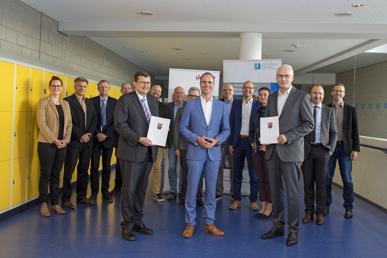 Wissenschaftsminister Clemens Hoch (Mitte) bei der Übergabe der Zuweisungsbescheide an Prof. Dr. Stefan Wehner (links vom Minister) und an Prof. Dr. Karl Stoffel (rechts vom Minister). Foto: Hochschule Koblenz/Gandner