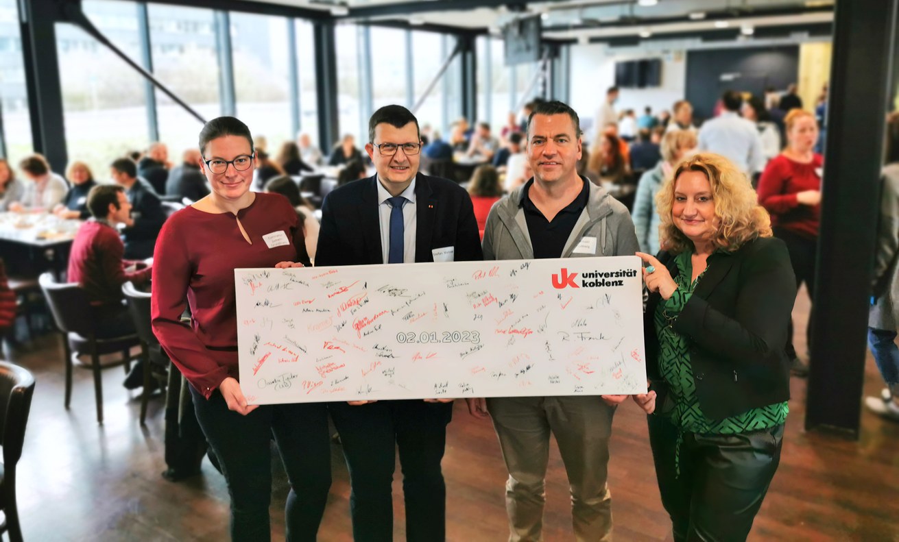 Auftaktveranstaltung in der Uni-Mensa der neuen Uni Koblenz mit Signierung einer Tafel durch die Mitarbeitenden. Im Bild, v.l.n.r.: Vizepräsidentin Prof. Dr. Constanze Juchem-Grundmann, Präsident Prof. Dr. Stefan Wehner, Kanzler Michael Ludewig, Vizepräsidentin Prof. Dr. Claudia Quaiser-Pohl. Bild: Universität Koblenz